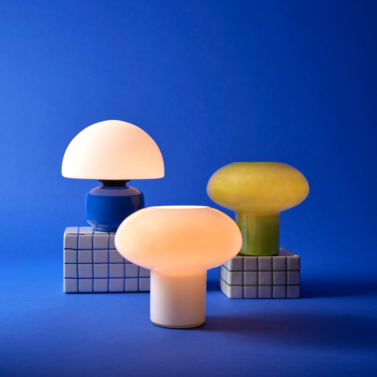 Teyo green glass table lamp styled with glowing lamps on a blue background
